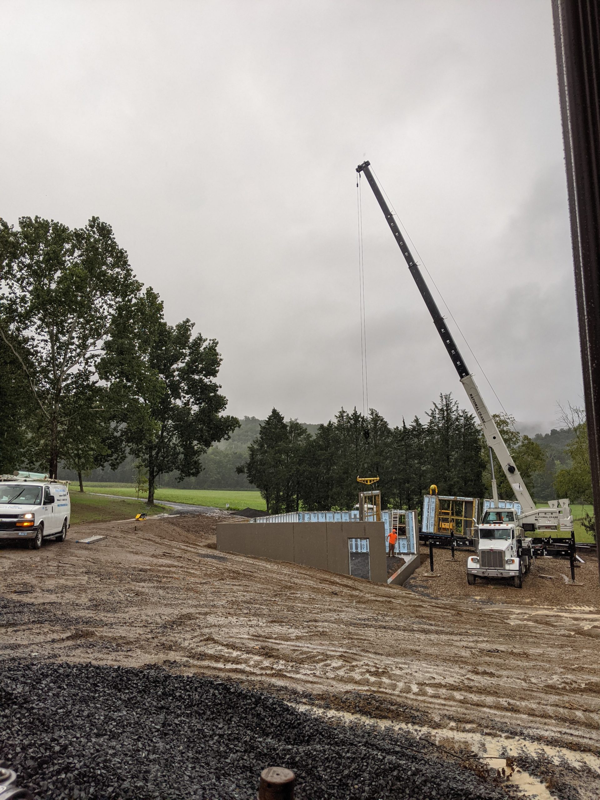 Mobile Crane installing concrete foundation for Pennsylvania Barn in September rain storm